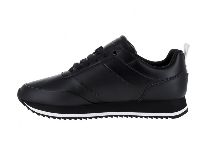 Tenis negros de cuero Calvin Klein con suela blanca dentada y cordones negros.