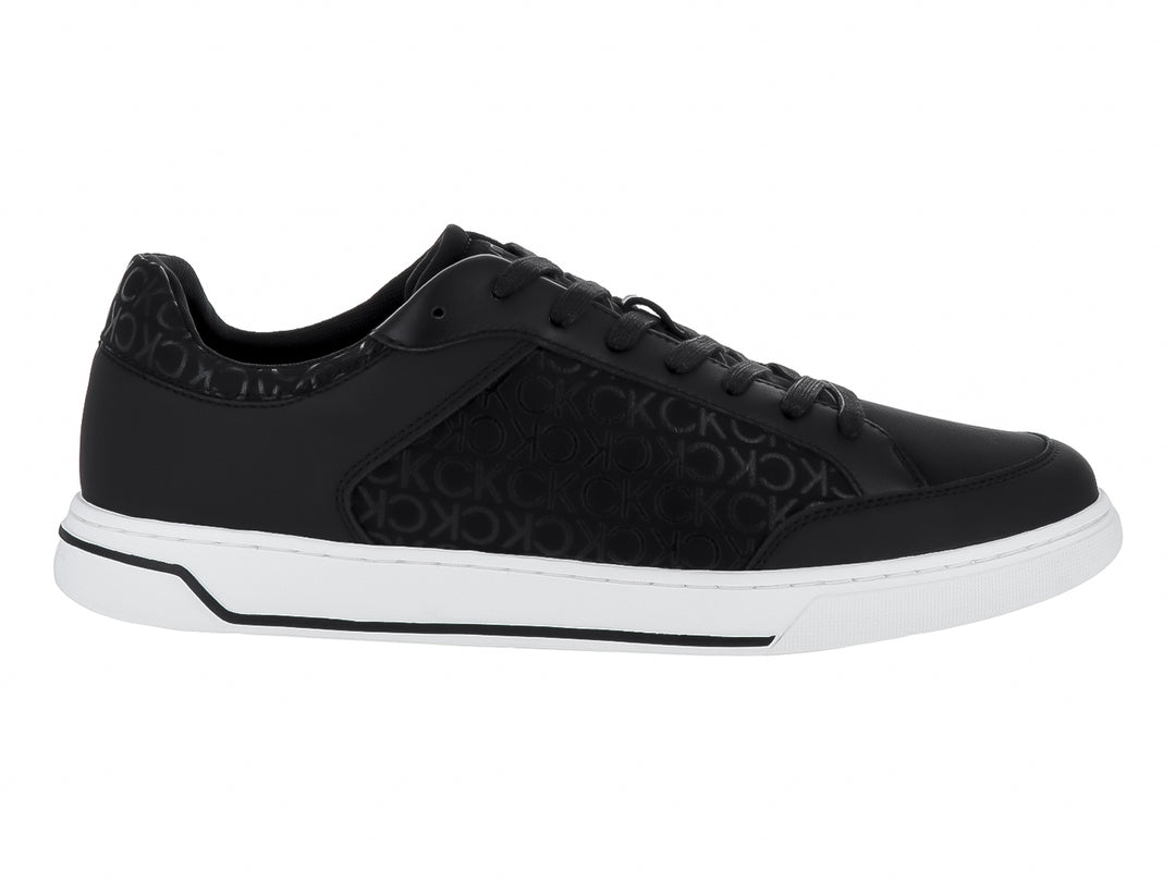 Tenis Calvin Klein color negro con monograma y suela blanca, diseño de corte bajo con cordones.