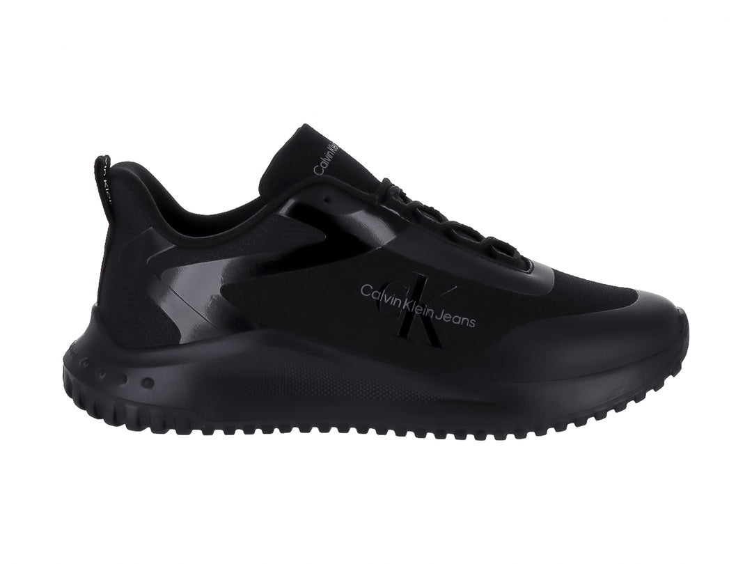 Tenis deportivos Calvin Klein color negro con suela gruesa y detalles brillantes.