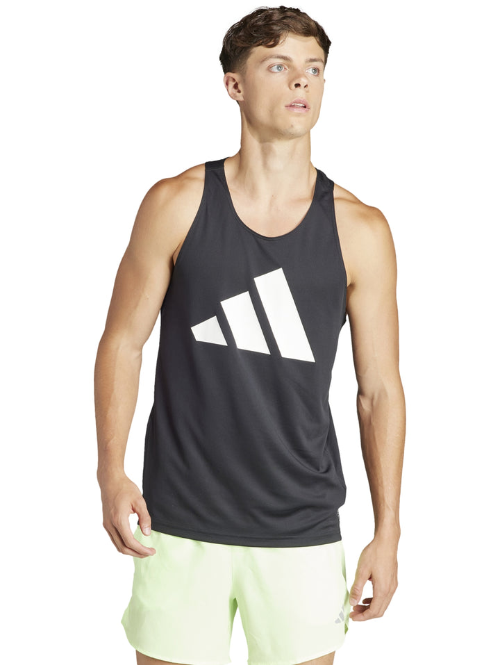 Hombre usando camiseta sin mangas Adidas negra con logo blanco y shorts deportivos verde claro.