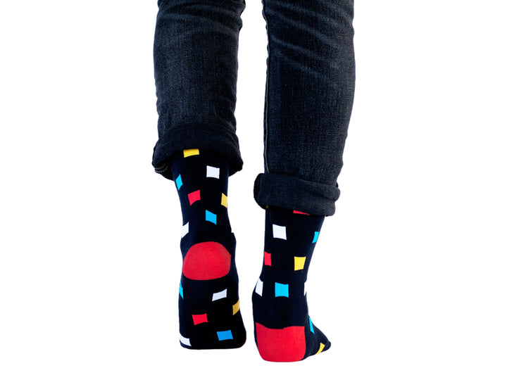 Par de calcetines azul marino con estampado de cuadros multicolores y punta roja.
