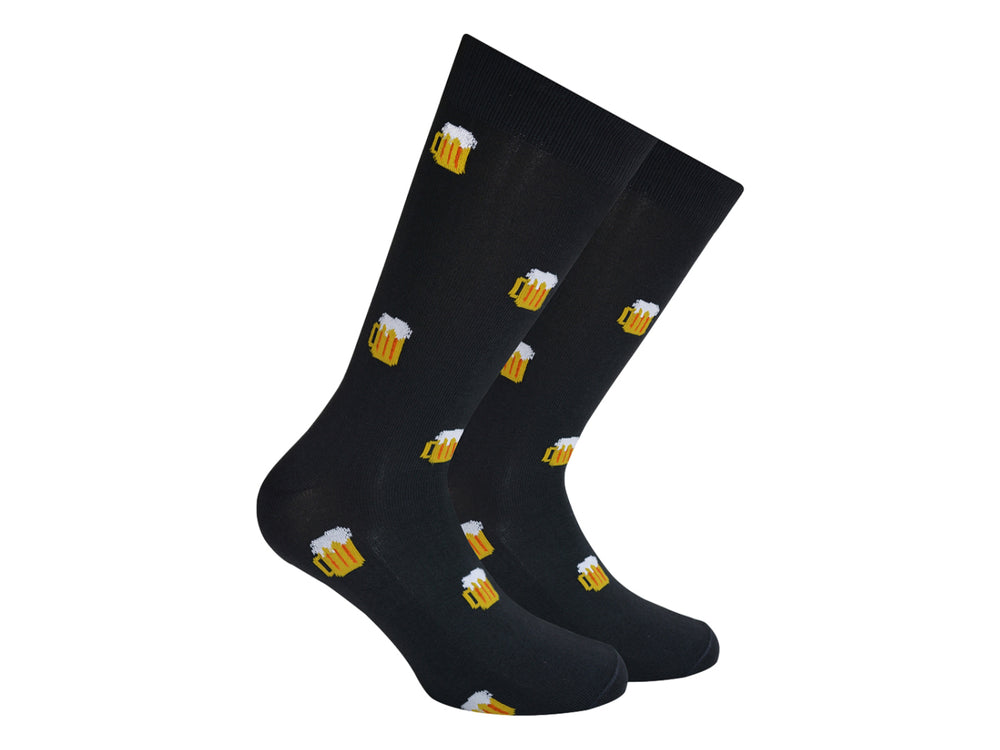 Par de calcetines negros con estampado de tarros de cerveza amarillos con espuma blanca.