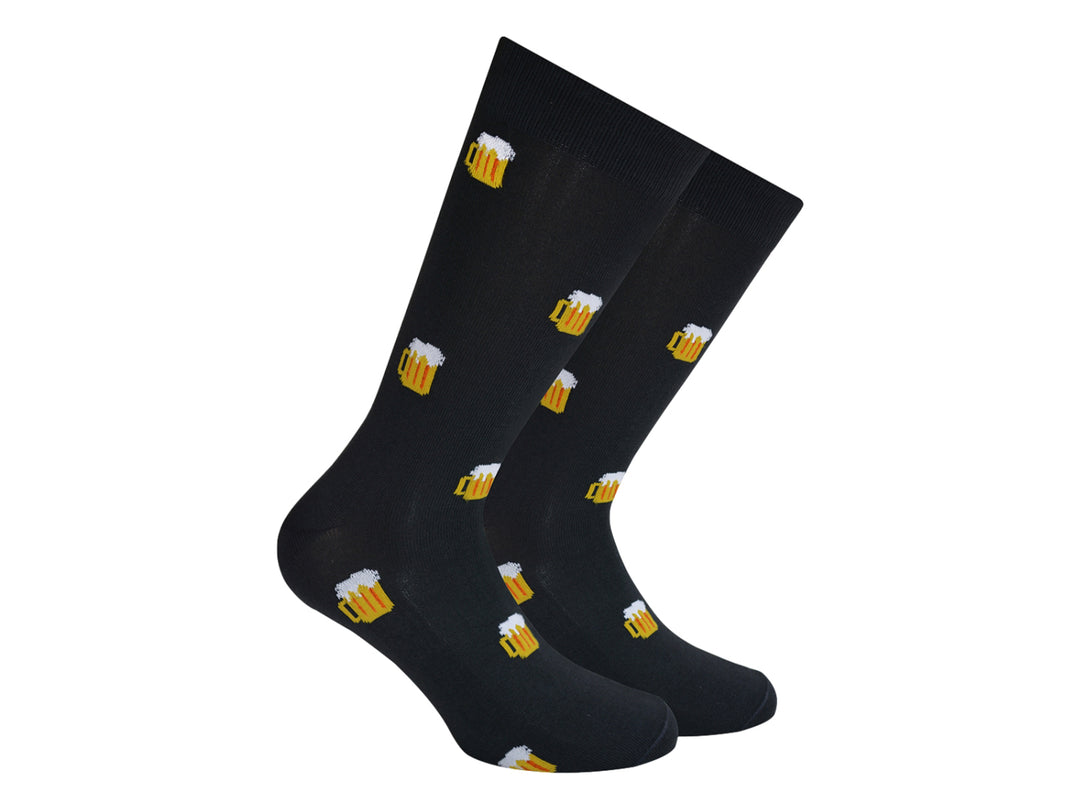 Par de calcetines negros con estampado de tarros de cerveza amarillos con espuma blanca.