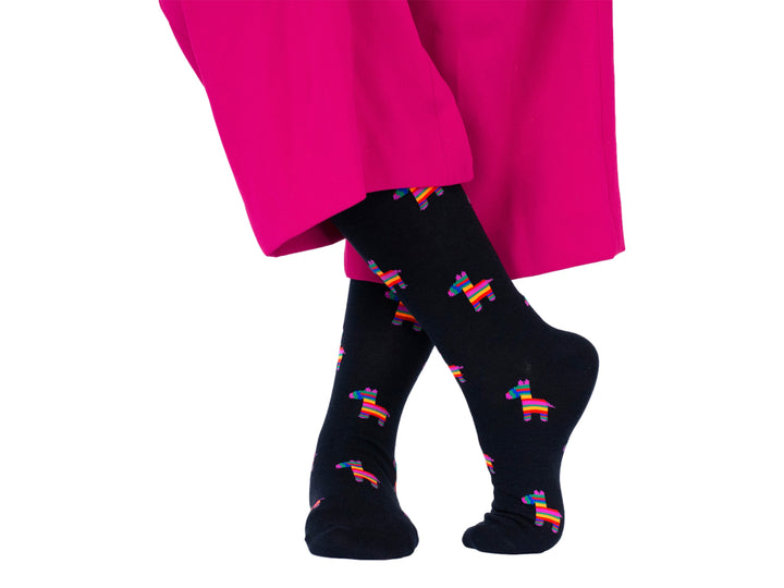 Par de calcetines negros con estampado de piñatas coloridas.