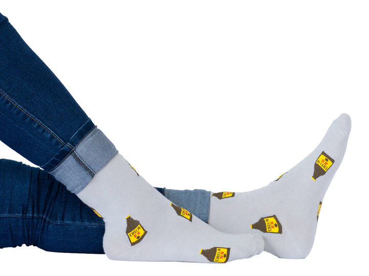 Par de calcetines color gris con estampado repetitivo de botellas de cerveza tipo caguama.