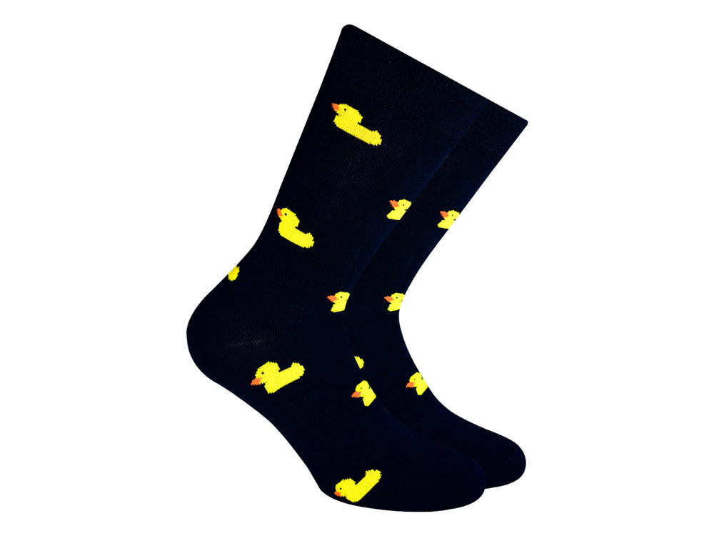 Par de calcetines negros con estampado de pequeños patitos amarillos.