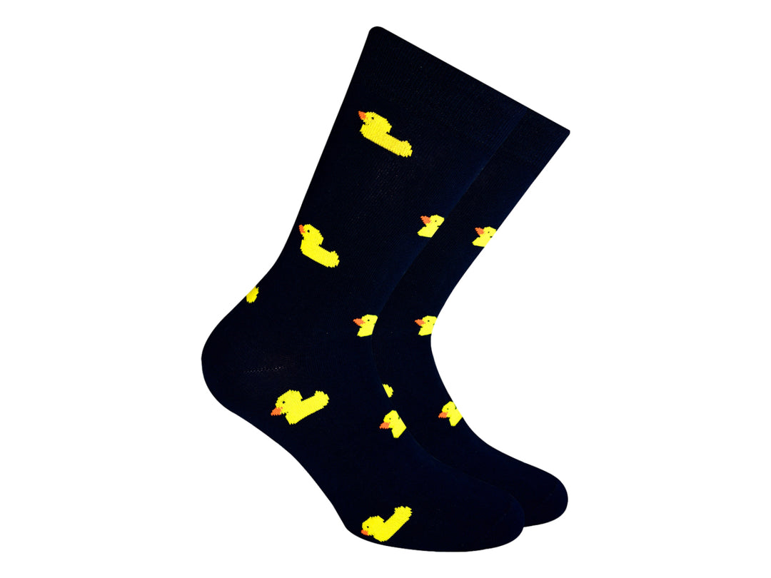 Par de calcetines negros con estampado de pequeños patitos amarillos.