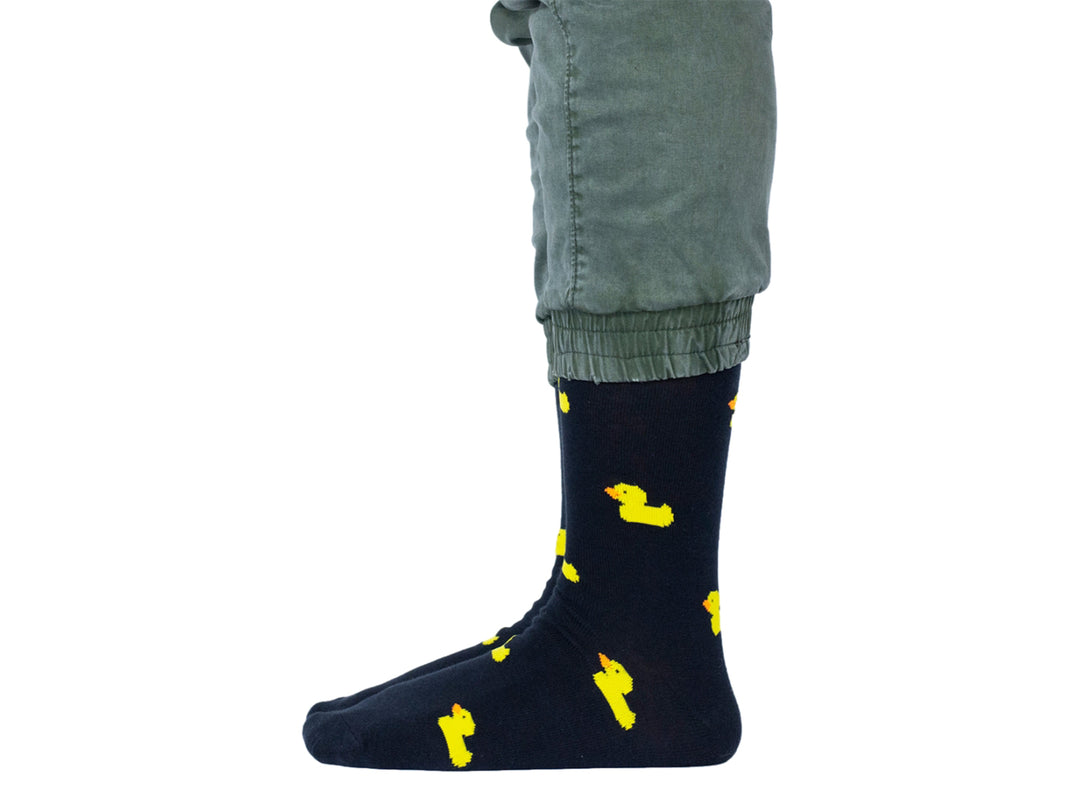 Par de calcetines negros con estampado de pequeños patitos amarillos.