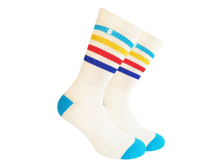 Par de calcetines blancos con rayas horizontales en azul, amarillo y rojo, y puntas azules.