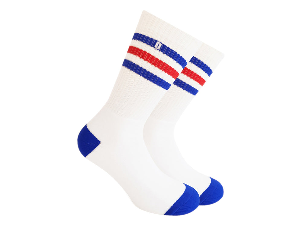 Par de calcetines blancos con rayas azules y rojas en la parte superior y punta azul.