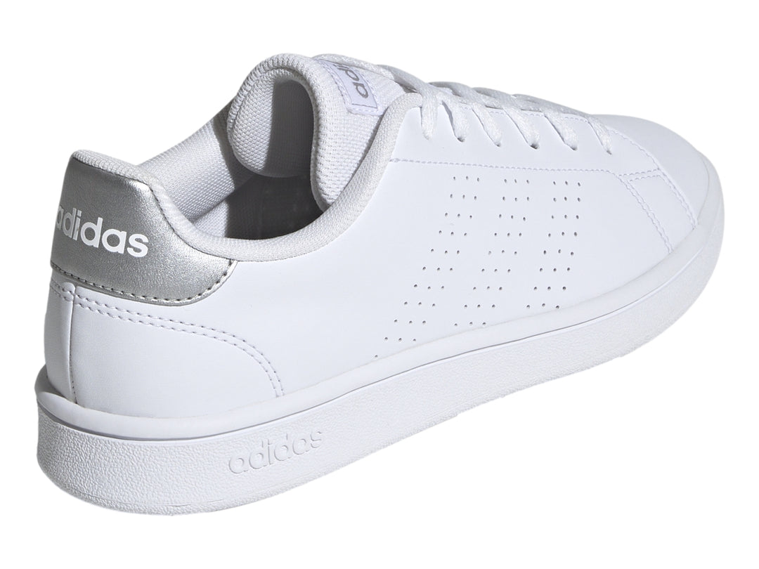 Tenis Adidas blancos con detalles plateados en el talón y suela blanca.