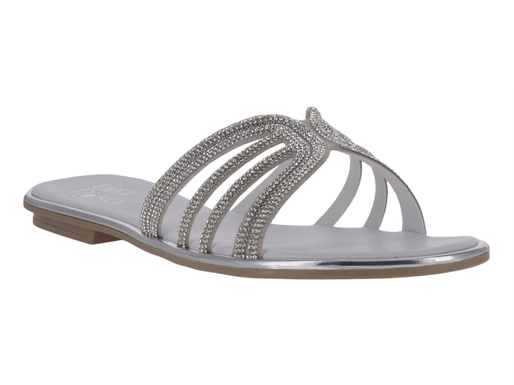 Sandalia plana color plata con tiras decoradas con pedrería brillante.