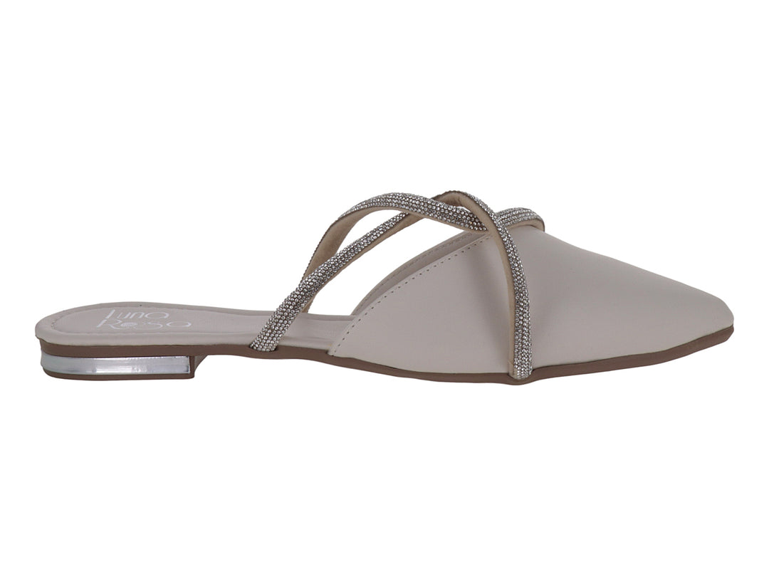 Zapato plano color latte con punta fina y correas cruzadas decoradas con pedrería brillante.