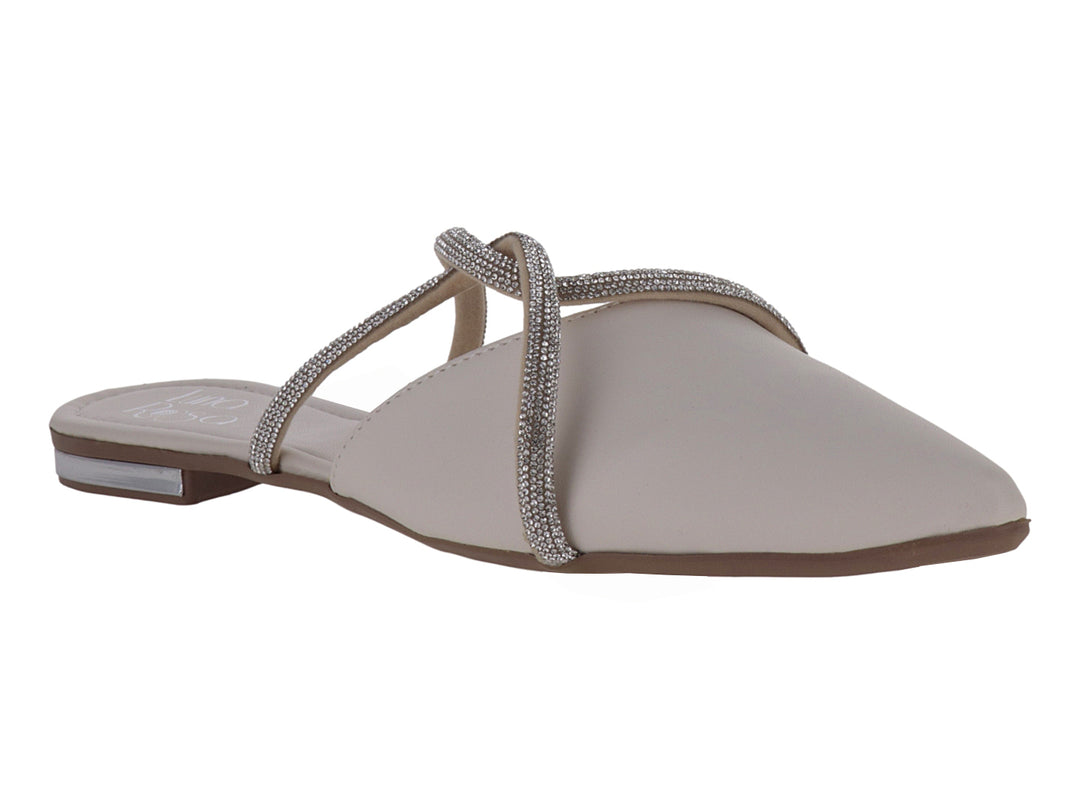 Zapato plano color latte con punta fina y correas cruzadas decoradas con pedrería brillante.
