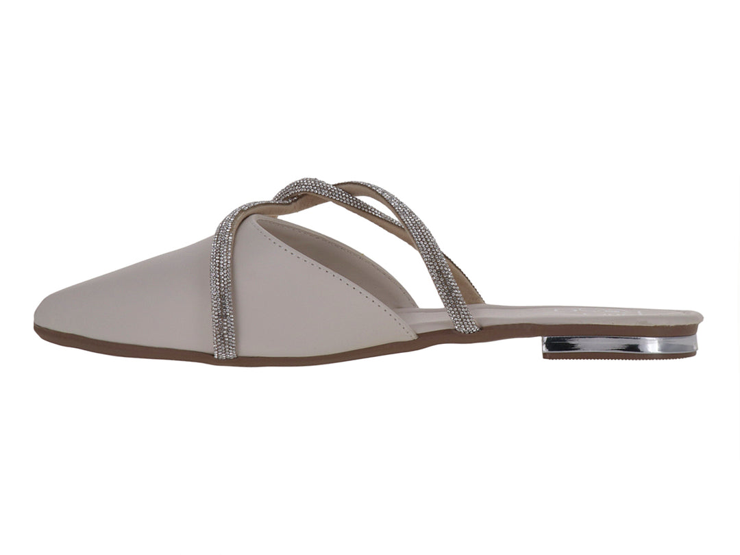 Zapato plano color latte con punta fina y correas cruzadas decoradas con pedrería brillante.