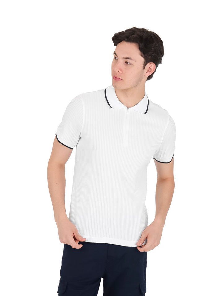 Playera polo blanca de manga corta con ribetes negros en el cuello y los bordes de las mangas.