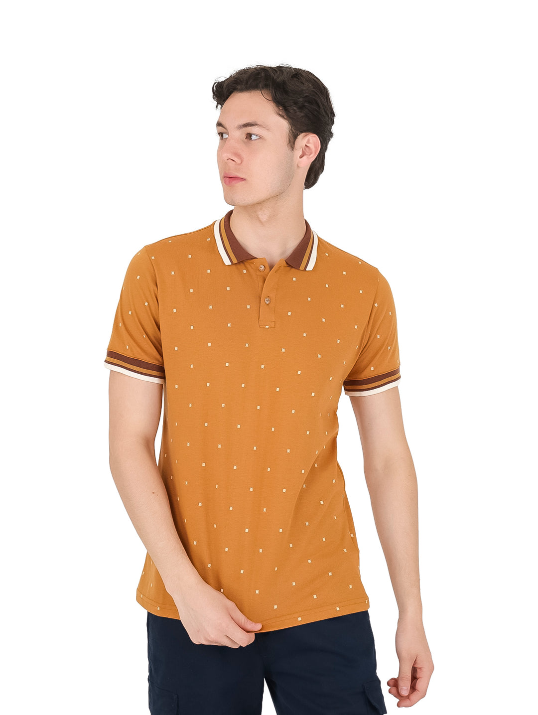 Hombre vistiendo playera polo color ocre con estampado de pequeños puntos blancos y detalles contrastantes en el cuello.