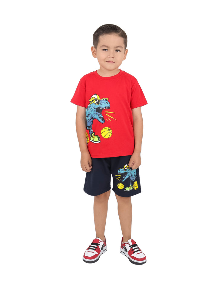 Niño con conjunto de camiseta roja y short azul marino con estampado de dinosaurio y tenis rojos.