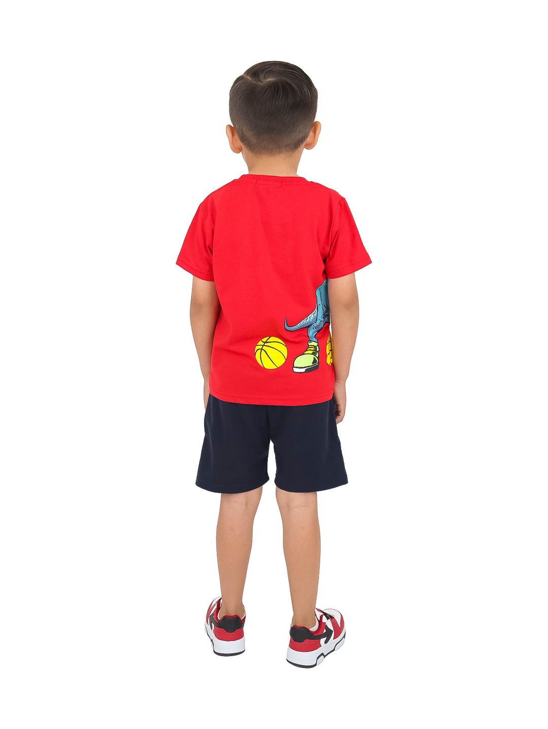 Niño con conjunto de camiseta roja y short azul marino con estampado de dinosaurio y tenis rojos.