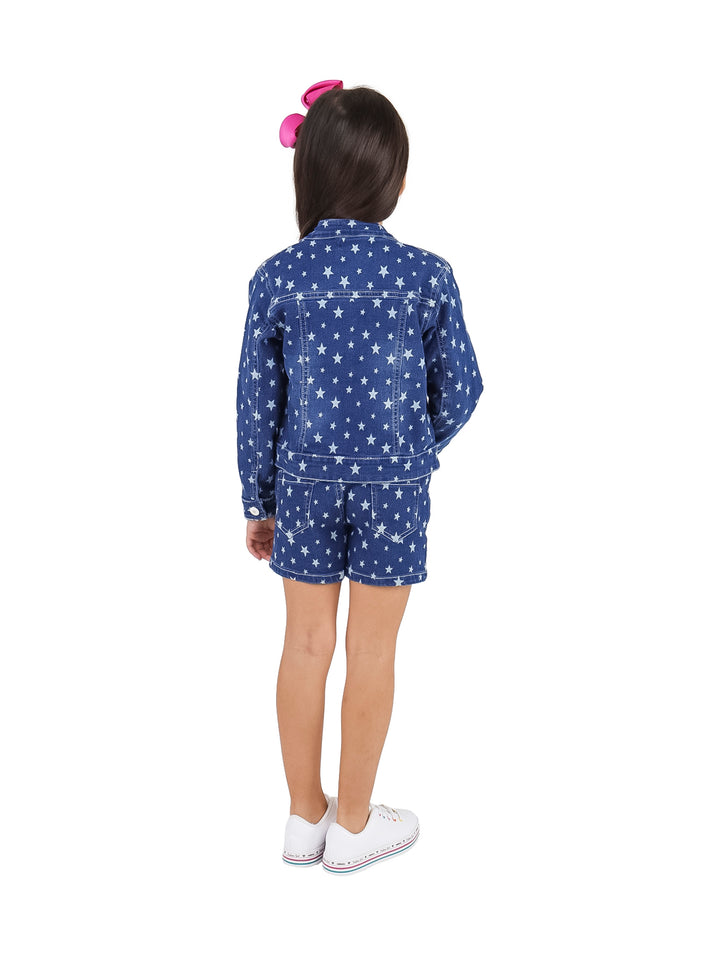 Niña vistiendo conjunto de chaqueta y short azul con estampado de estrellas blancas y camiseta blanca.