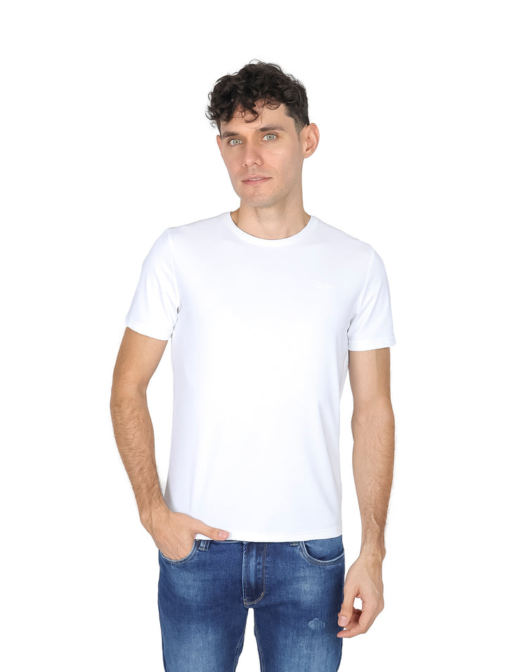 Hombre vistiendo una playera blanca de manga corta y cuello redondo con jeans azules.