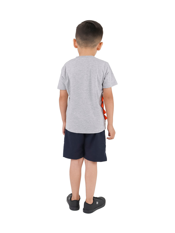 Niño vistiendo un conjunto de camiseta gris y short azul marino con estampado de dinosaurio.