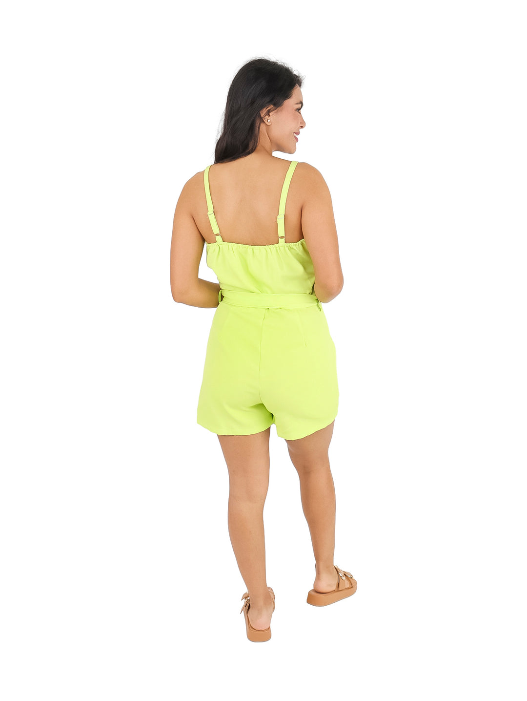 Mujer vistiendo un jumper corto color verde neón con botones laterales y cinturón ajustable.