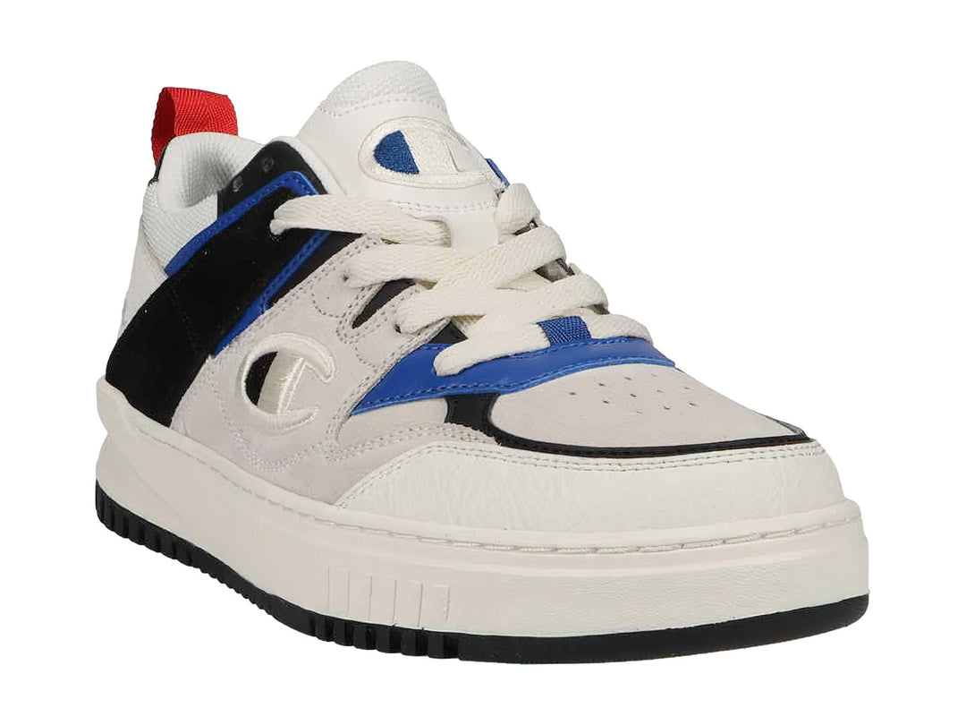 Tenis Champion blancos con detalles en azul y negro, suela blanca y lengüeta roja trasera.