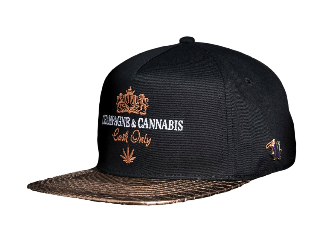 Gorra snapback color negro con visera dorada y bordados frontales de Champagne & Cannabis Cash Only.