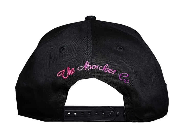 Gorra snapback negra con visera rosa estampada y bordado blanco que dice &