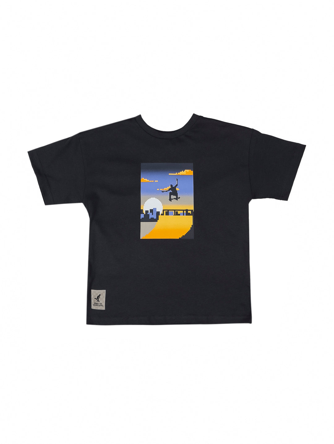 Camiseta negra de manga corta para niño con un estampado rectangular central de un skate park en colores amarillo y azul.