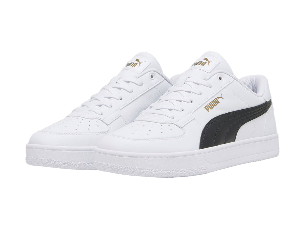Tenis PUMA blancos con franja negra lateral y detalles dorados en la lengüeta.