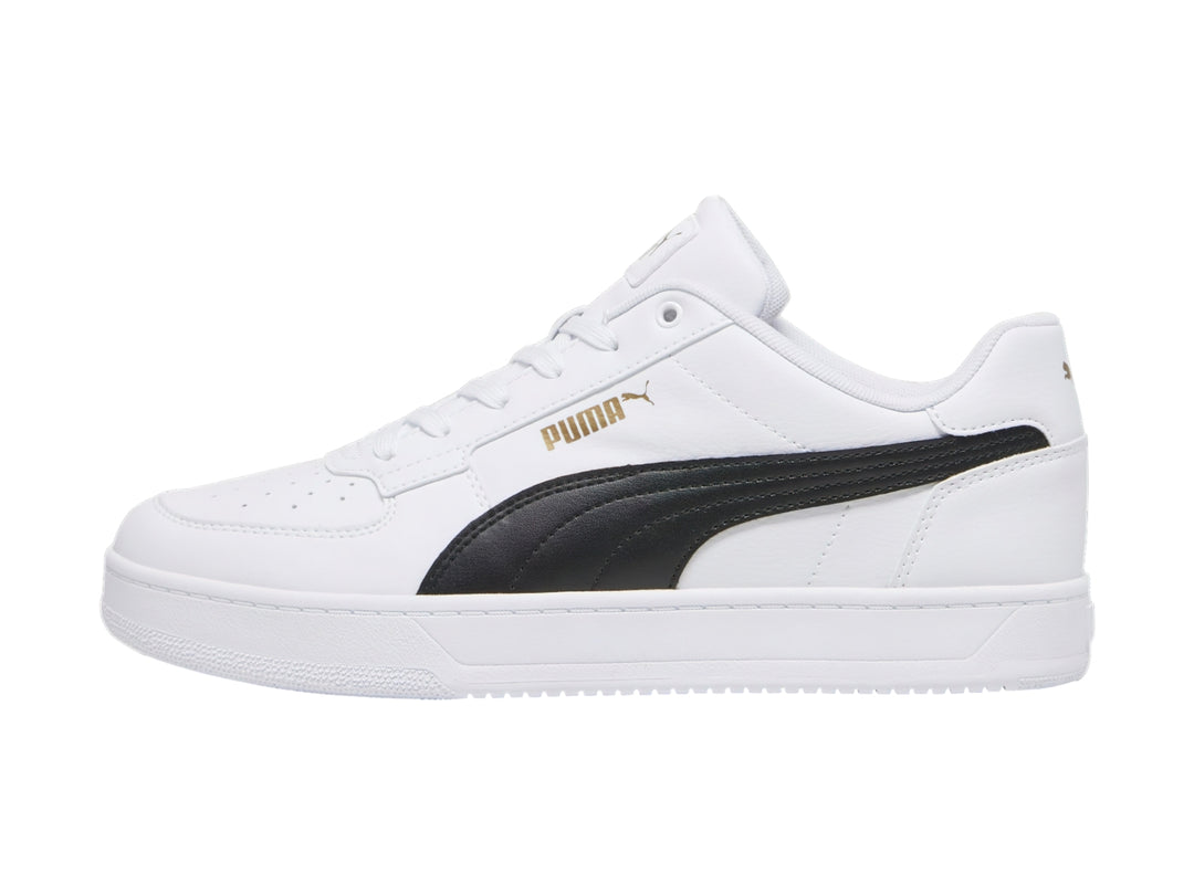 Tenis PUMA blancos con franja negra lateral y detalles dorados en la lengüeta.