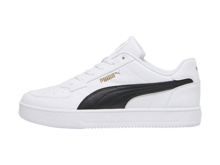 Tenis PUMA blancos con franja negra lateral y detalles dorados en la lengüeta.