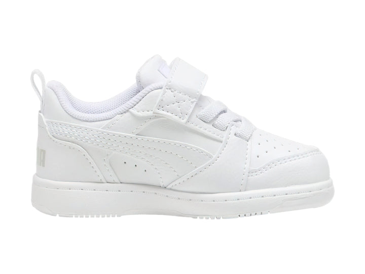 Tenis PUMA Rebound V6 Lo AC+PS en color blanco con detalles en gris claro y cierre de velcro para niños.
