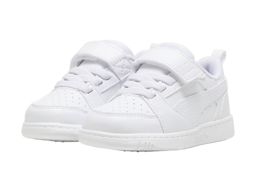 Tenis PUMA Rebound V6 Lo AC+PS en color blanco con detalles en gris claro y cierre de velcro para niños.