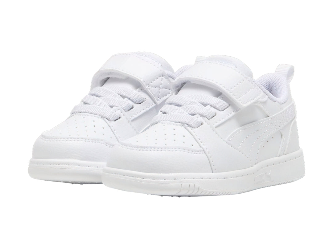 Tenis PUMA Rebound V6 Lo AC+PS en color blanco con detalles en gris claro y cierre de velcro para niños.