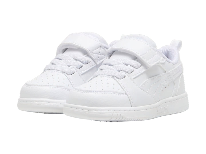 Tenis PUMA Rebound V6 Lo AC+PS en color blanco con detalles en gris claro y cierre de velcro para niños.