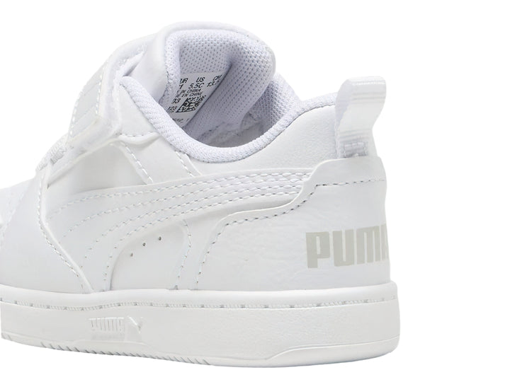 Tenis PUMA Rebound V6 Lo AC+PS en color blanco con detalles en gris claro y cierre de velcro para niños.