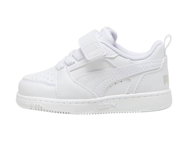 Tenis PUMA Rebound V6 Lo AC+PS en color blanco con detalles en gris claro y cierre de velcro para niños.