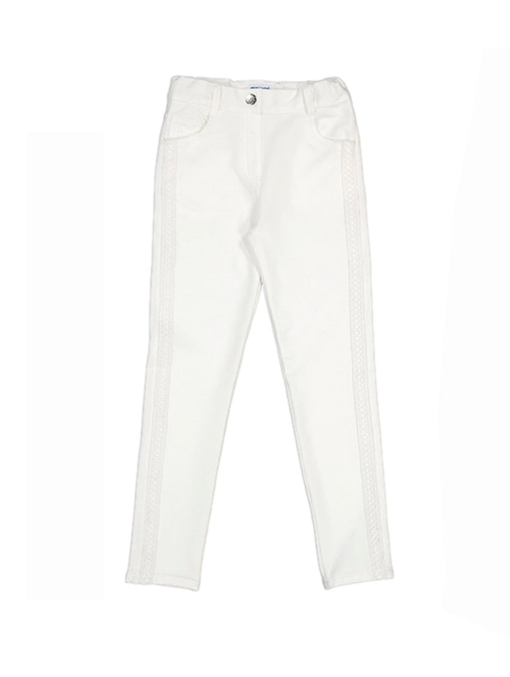 Pantalón color crudo para niña con detalles decorativos laterales.