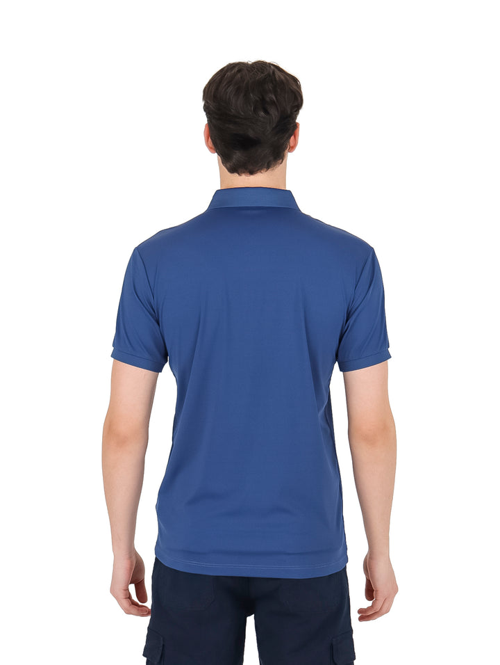 Hombre vistiendo una playera polo de color azul con un estampado sutil y cuello clásico.