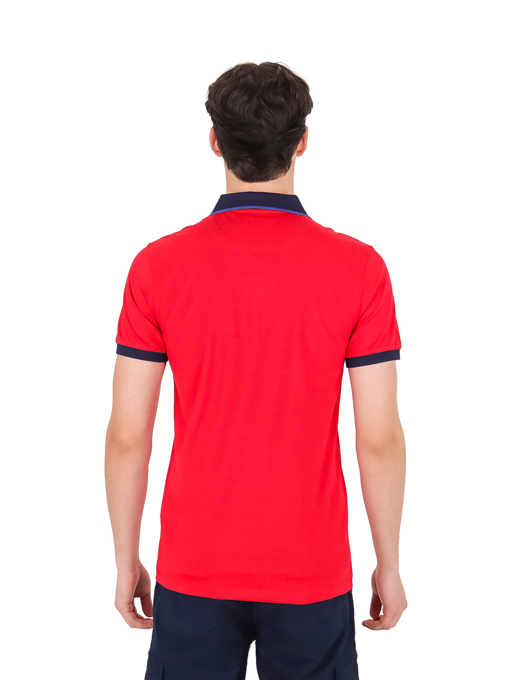 Hombre vistiendo playera polo color rojo con detalles en azul marino en el cuello y mangas.