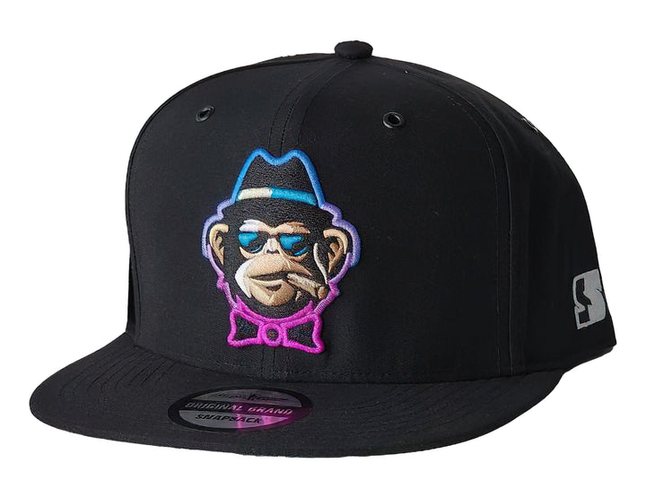Gorra snapback color negro con un parche bordado de un mono con lentes y sombrero en el frente.