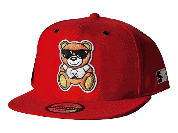 Gorra snapback color rojo con un parche bordado de un oso con lentes de sol en el frente.