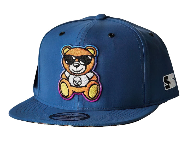 Gorra snapback azul con un parche frontal de un oso con lentes de sol.