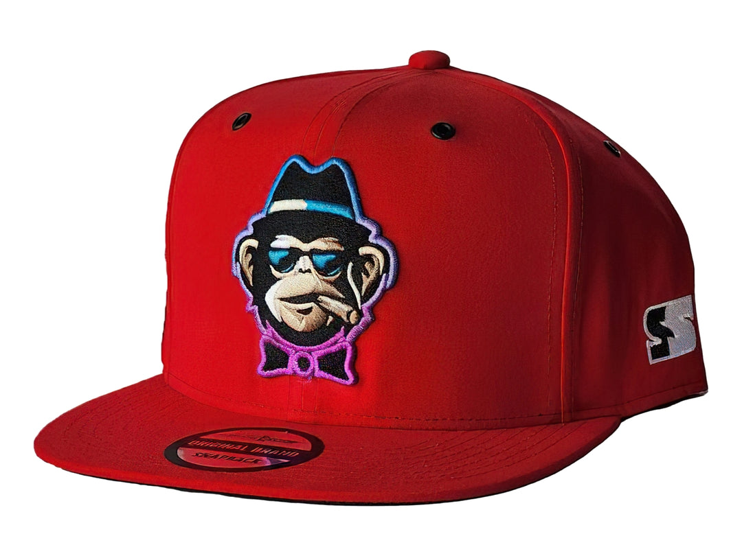 Gorra snapback color rojo con un parche frontal bordado de un mono con lentes y sombrero.