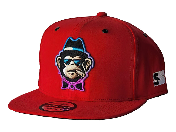 Gorra snapback color rojo con un parche frontal bordado de un mono con lentes y sombrero.