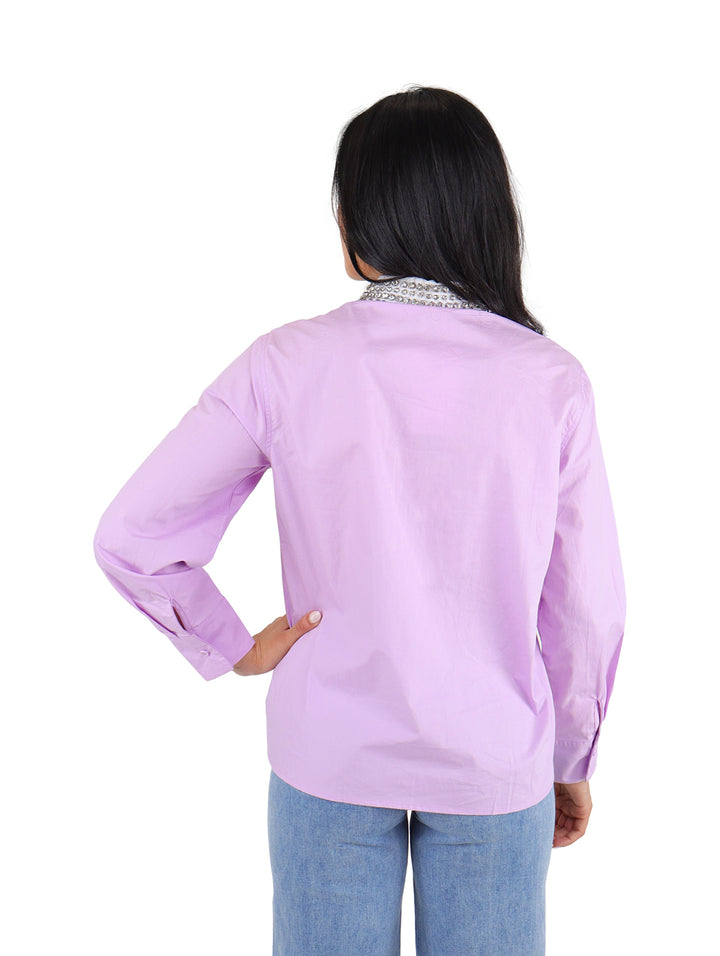 Camisera lila de manga larga con detalles de piedras brillantes en el cuello.