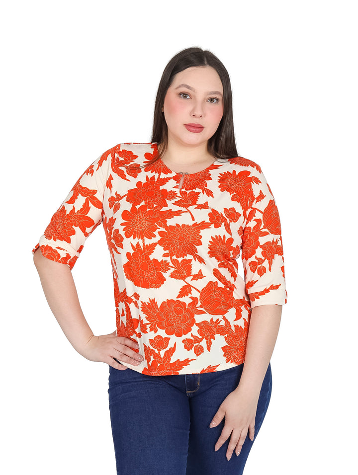 Mujer vistiendo blusa blanca con estampado floral naranja y mangas 3/4.